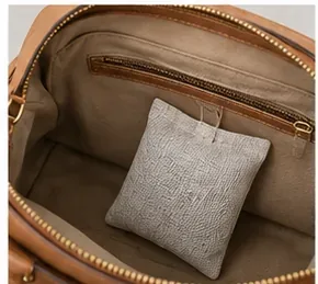 Clean purse interior with a small contained sachet placed inside after the bag has fully dried