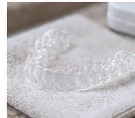 A clean clear retainer resting on a fresh towel to air dry before storage.