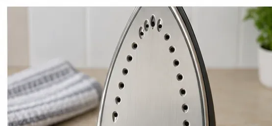 Clean silver steam iron soleplate after burnt residue has been removed