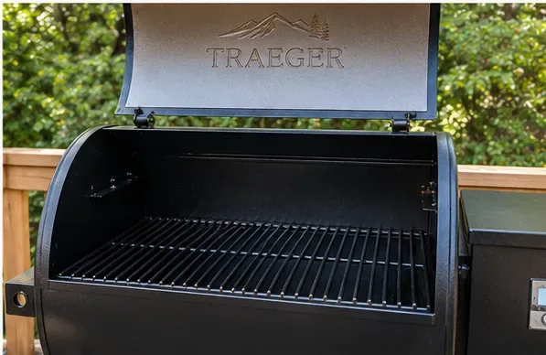 A clean Traeger pellet grill with the lid open and cooking grates reinstalled in the barrel.