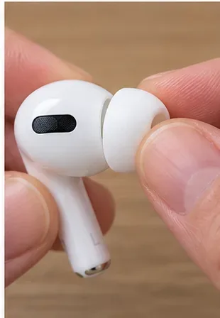 ภาพระยะใกล้ของจุกหูฟัง AirPods Pro ที่แห้งสนิท กำลังถูกจัดวางและกดกลับเข้าไปในตัวเชื่อมต่อหูฟัง