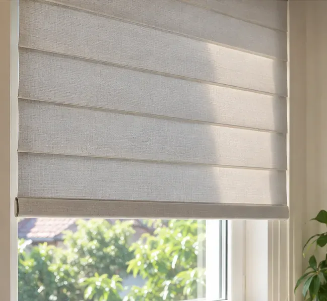 A clean beige fabric blind hanging evenly in a bright window after drying