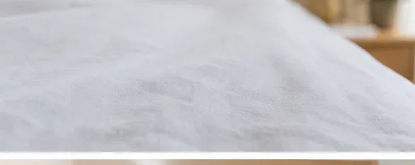 A freshly washed white sheet spread flat for close inspection before drying